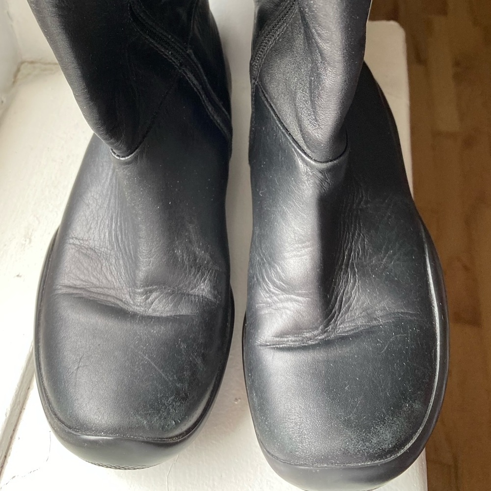 Girls zip up Prada leather boots.